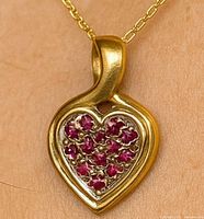 Front view of pendant on chain, showing heart shape and ruby arrangement