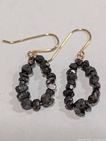 front view of both earrings showing gold hooks and black diamond oval loops