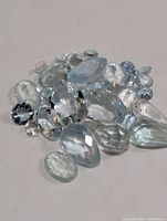 Group of pale blue faceted aquamarine stones on neutral background