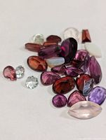 Loose faceted gemstones spread out to show cuts and colours