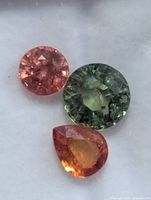 Close-up of three loose sapphires showing colours and cuts
