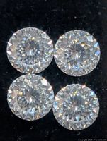 Close-up of four round moissanite stones showing facets and clarity