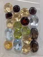 Front view of sealed packet displaying assorted loose gemstones