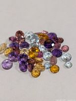 Pile of assorted faceted gemstones showing variety of colours and cuts