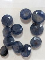 Group of loose faceted blue sapphires on white background