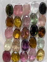Front view of 25 multi-coloured oval tourmalines