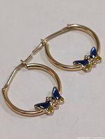 Both 10K gold hoop earrings showing blue and yellow enamel butterflies