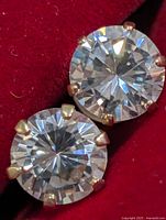 Close-up of both cubic zirconia studs showing six-prong yellow gold settings