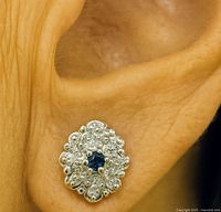 Earring worn on ear highlighting size and sparkle