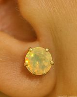 Opal stud earring in ear showing size and setting