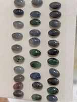 Front view of 40 oval cabochon gemstones on card