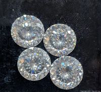 Close-up of four round brilliant moissanite stones