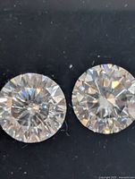 Close-up of two round brilliant moissanite stones showing facets and clarity
