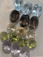 Assorted faceted gemstones in several colors arranged in rows