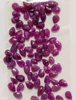 Group of loose pear-cut rubies on card