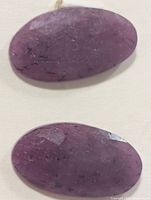 Front view of both oval rubies showing color and inclusions