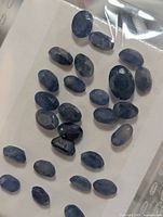 Group of loose blue sapphires in plastic sleeve