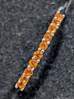 Close-up of orange sapphire row showing stone color and setting