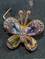 Front view of butterfly pendant showing multicolour gemstones and pavé accents