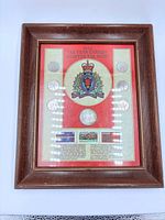 front view of framed display showing coins, stamps and RCMP crest
