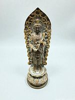 Front view of bronze standing Buddha with aureola and lotus base