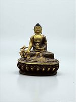 Front view of gilt bronze Medicine Buddha on lotus pedestal
