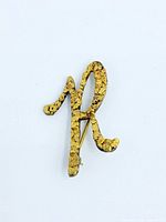 Front view of gold nugget cluster brooch shaped as letter R