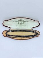 Necklace in open Lotus Pearls case showing branding and full length strands