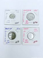 Obverse side of four silver coins in flips with handwritten details