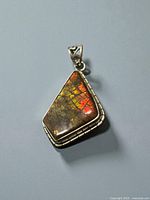 Front view of pendant showing ammolite colors and bezel
