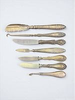 Seven sterling-handled utensils laid out front view