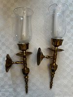 Front view showing both brass wall sconces with glass shades and candles