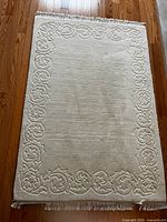 Full view of cream rug showing size and border design