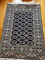 Full view of dark blue oriental rug showing pattern and fringe