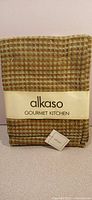 Front view of olive green Alkaso tea towel set in packaging