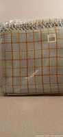 Front view of packaged blue plaid cotton throw