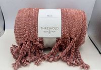 Rolled pink chenille throw with Threshold tag visible
