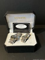 Open Geneva case showing both watches and guarantee card
