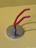 angled view of magnetic holder showing red prongs and steel base