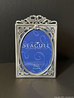 Front view showing full pewter frame, floral and bell design, Seagull insert