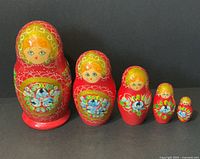 Front view of all five nesting dolls lined up largest to smallest