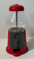 Front view of red Continental gumball machine showing coin mechanism and chute
