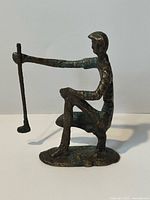 Full side view of bronze golfer sculpture