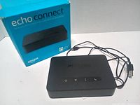 Top view of Echo Connect with buttons, power cable and retail box