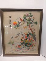 Full view of framed silk embroidery with birds, tree and calligraphy