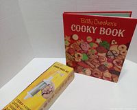 Front view showing Betty Crocker's Cooky Book and sealed cookie press box