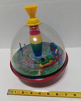 Top view showing entire spinning top with ruler indicating approx 8 in. diameter