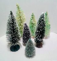 Group of eight bottle brush Christmas trees showing size and color variations