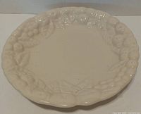 Top view showing embossed fruit motif and scalloped rim