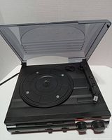 Turntable top view with dust cover open showing platter and tonearm